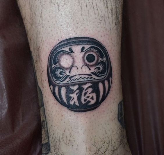 tattoo búp bê daruma 3d ở cổ chân