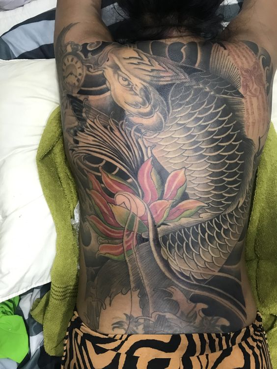 tattoo cá chép đen kết hợp với hoa bít lưng