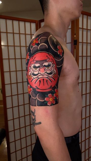 mẫu xăm hình daruma mặt giận kết hợp hoa anh đào đỏ phong cách Nhật Bản