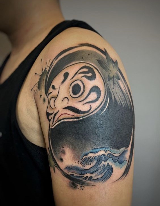 xăm hình đen trắng daruma mặt tròn trên bắp tay