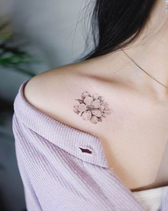 tattoo bông hoa mini đen trắng ở xương quai xanh