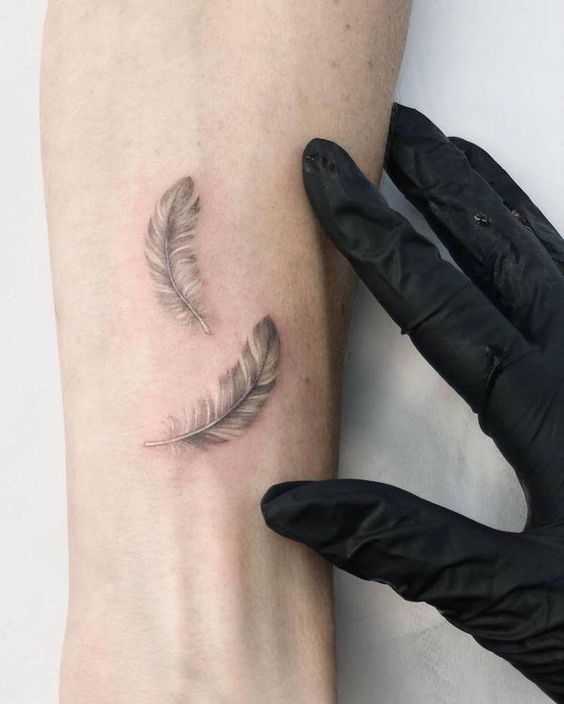 mẫu tattoo cặp lông vũ đẹp cho nam trên tay