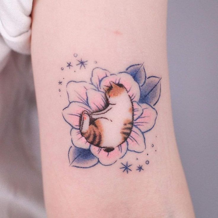 mẫu tattoo con mèo nằm trên bông hoa